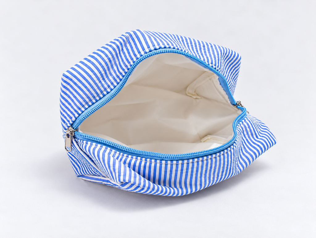 Seersucker Bow Makeup Bag in Blue Stripe, open with white lining