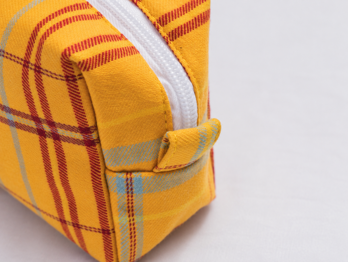 Brushed Plaid Makeup Bag in marigold, end tab detail