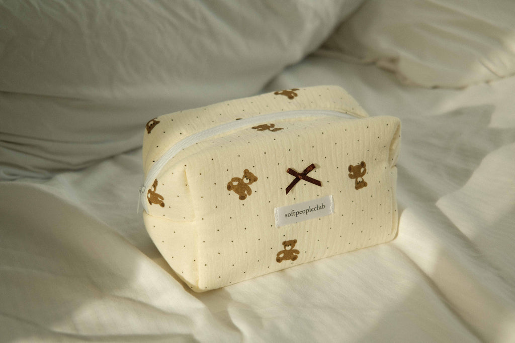 Padded Teddy Dot Makeup Bag, styled on bed in sunlight